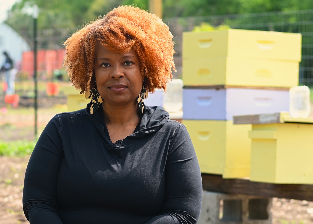 A photo of Mika Hardison with her beekeeping equipment.